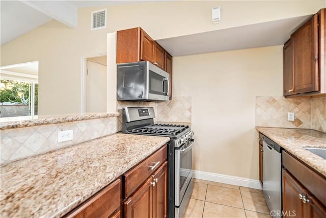 2017 W Newgrove St, Lancaster, CA 93536 - kitchen with appliances with stainless steel finishes, light stone countertops, tasteful backsplash, and light tile patterned flooring