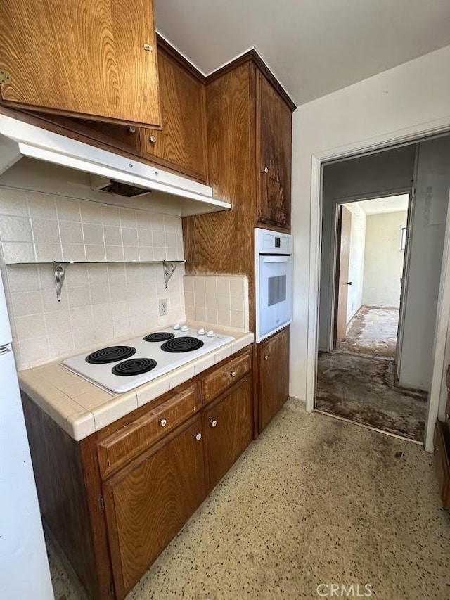 505 Cedar Ave Unit 2A, Long Beach, CA 90802 - kitchen featuring white appliances, tile counters, and decorative backsplash