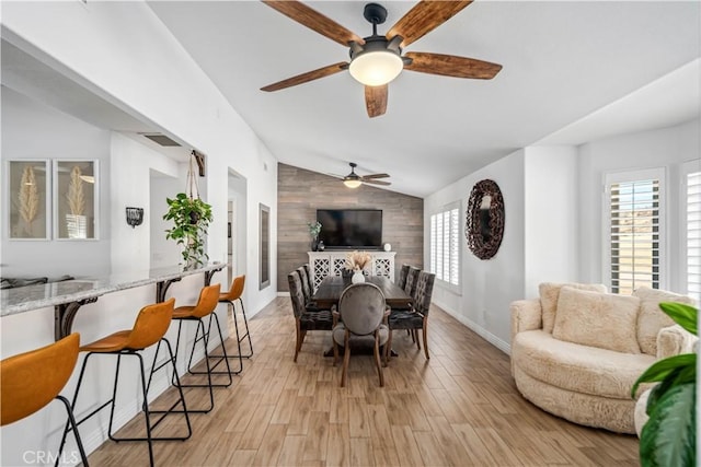 32175 Cedarcroft Rd, Acton, CA 93510 - dining room featuring lofted ceiling, ceiling fan, light wood finished floors, wooden walls, and an accent wall