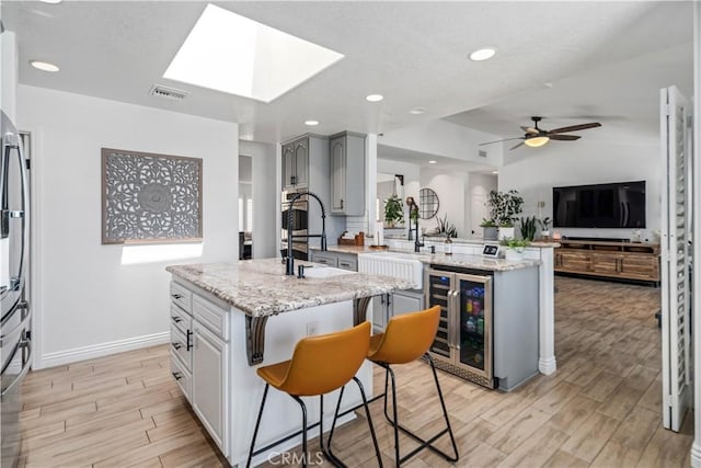 32175 Cedarcroft Rd, Acton, CA 93510 - kitchen featuring beverage cooler, a peninsula, light wood finished floors, a ceiling fan, and recessed lighting