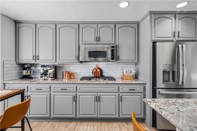 32175 Cedarcroft Rd, Acton, CA 93510 - kitchen with appliances with stainless steel finishes, gray cabinetry, decorative backsplash, light stone countertops, and recessed lighting