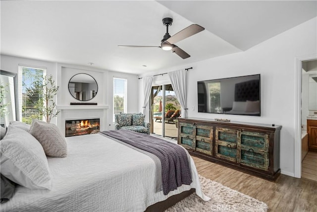 32175 Cedarcroft Rd, Acton, CA 93510 - bedroom featuring access to exterior, wood finished floors, a glass covered fireplace, ensuite bath, and a ceiling fan