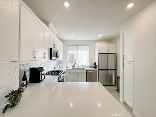 3700 Verdana Cir, La Verne, CA 91750 - kitchen featuring appliances with stainless steel finishes, recessed lighting, decorative backsplash, white cabinets, and light countertops