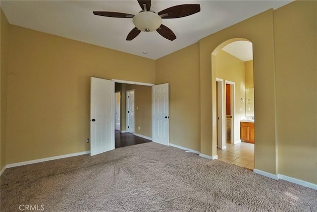 845 E Redwood Cir, Hanford, CA 93230 - unfurnished bedroom with carpet floors, arched walkways, ensuite bath, and a ceiling fan