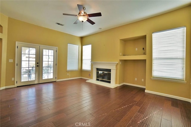 845 E Redwood Cir, Hanford, CA 93230 - unfurnished living room with ceiling fan, a glass covered fireplace, dark wood-style flooring, french doors, and built in features