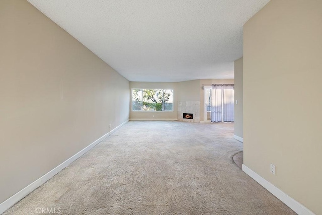 5870 Green Valley Cir Unit 231, Culver City, CA 90230 - unfurnished living room featuring a tiled fireplace, carpet flooring, and a textured ceiling