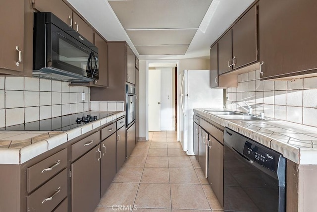 5870 Green Valley Cir Unit 231, Culver City, CA 90230 - kitchen with black appliances, tile countertops, light tile patterned flooring, and decorative backsplash