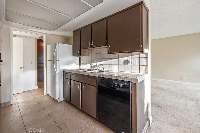 5870 Green Valley Cir Unit 231, Culver City, CA 90230 - kitchen with black dishwasher, tile counters, freestanding refrigerator, backsplash, and dark brown cabinets