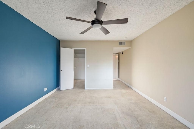 5870 Green Valley Cir Unit 231, Culver City, CA 90230 - unfurnished bedroom with a textured ceiling, carpet floors, a ceiling fan, and a walk in closet