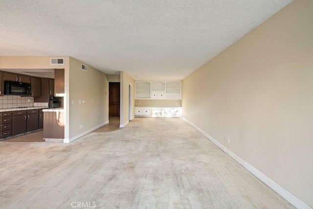 5870 Green Valley Cir Unit 231, Culver City, CA 90230 - unfurnished living room with light colored carpet and a textured ceiling