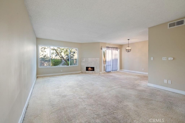 5870 Green Valley Cir Unit 231, Culver City, CA 90230 - unfurnished living room with a textured ceiling, carpet, a chandelier, and a tile fireplace