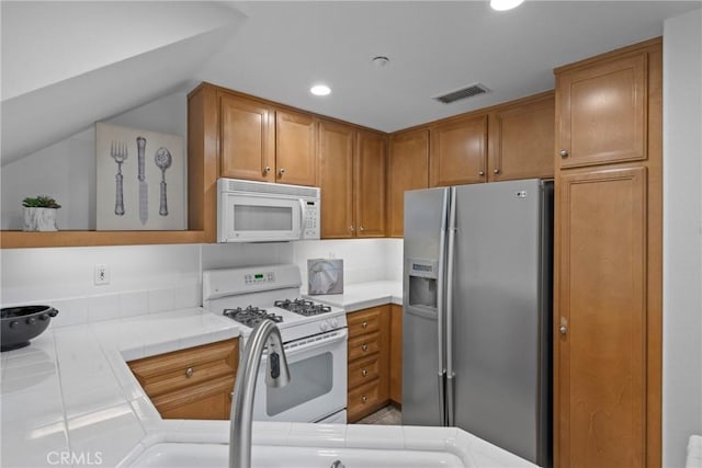 322 Dewdrop, Irvine, CA 92603 - kitchen with white appliances, tile countertops, recessed lighting, brown cabinets, and lofted ceiling