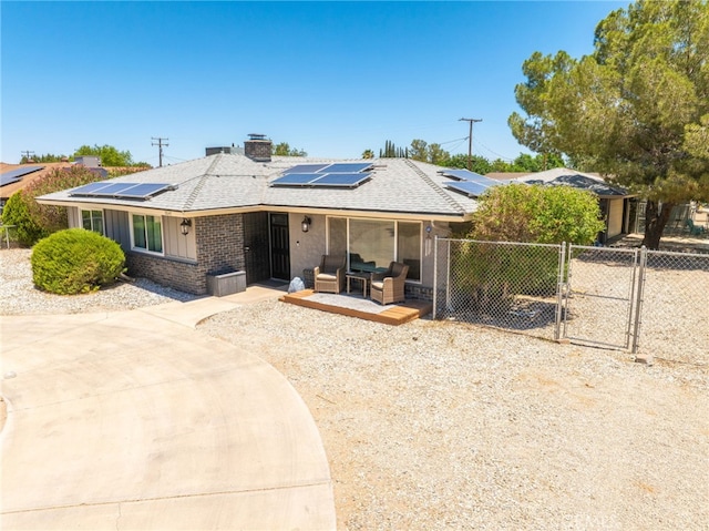 10147 Primrose Ave, Hesperia, CA 92345 - view of front of home with a gate, brick siding, a shingled roof, and solar panels