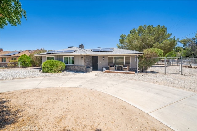 10147 Primrose Ave, Hesperia, CA 92345 - view of front of property with solar panels, brick siding, board and batten siding, a chimney, and a gate