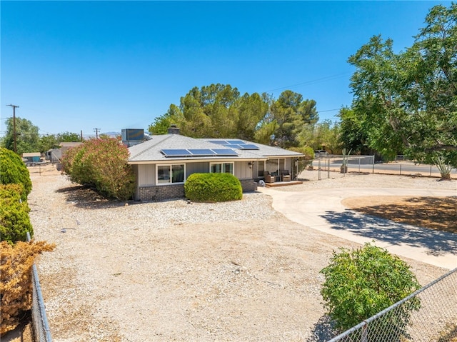 10147 Primrose Ave, Hesperia, CA 92345 - view of front of house with solar panels, curved driveway, brick siding, and board and batten siding
