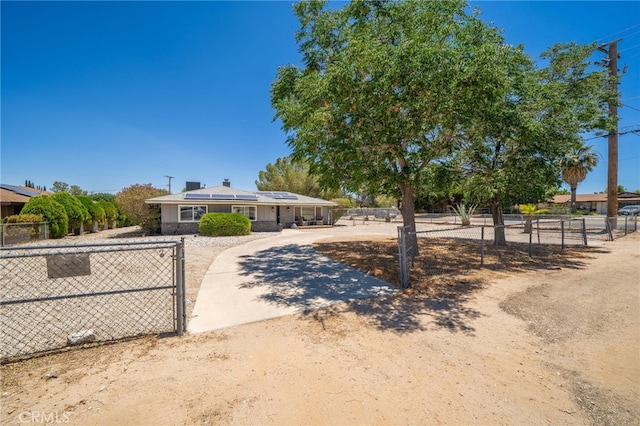 10147 Primrose Ave, Hesperia, CA 92345 - view of front of house featuring roof mounted solar panels, a chimney, and a gate