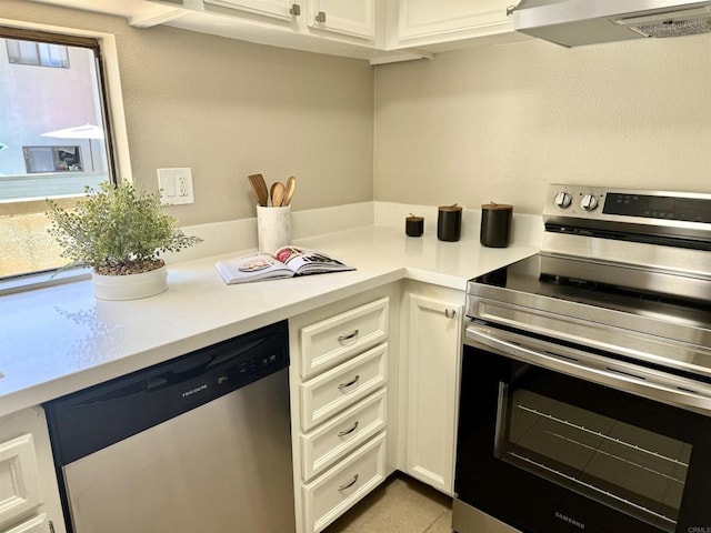 6182 Agee St Unit 193, San Diego, CA 92122 - kitchen with appliances with stainless steel finishes, extractor fan, light countertops, white cabinets, and light tile patterned flooring
