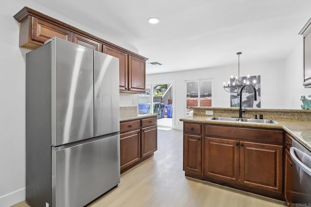 6876 Bear River Row Unit 3, San Diego, CA 92139 - kitchen with appliances with stainless steel finishes, light wood-style floors, a chandelier, decorative light fixtures, and recessed lighting