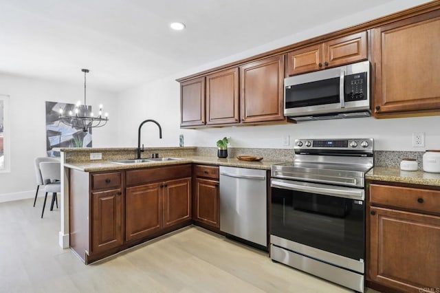 6876 Bear River Row Unit 3, San Diego, CA 92139 - kitchen with appliances with stainless steel finishes, a chandelier, a peninsula, recessed lighting, and light wood-style floors