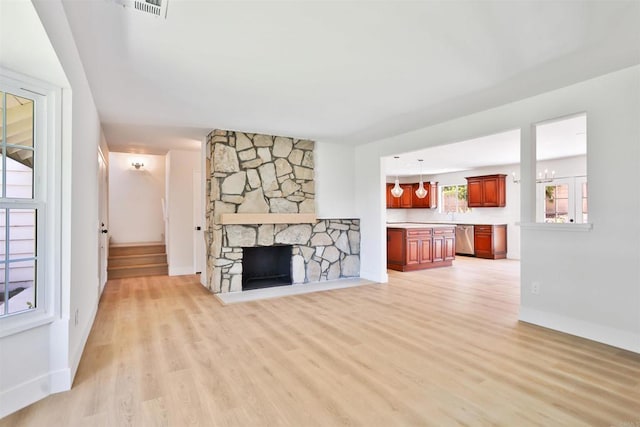 286 E Mission Rd, Corona, CA 92879 - unfurnished living room with light wood-type flooring, a stone fireplace, and a chandelier