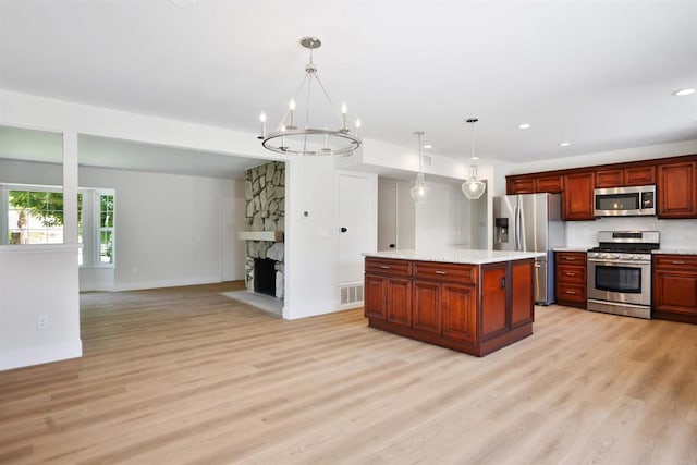 286 E Mission Rd, Corona, CA 92879 - kitchen featuring stainless steel appliances, light wood finished floors, light countertops, open floor plan, and pendant lighting