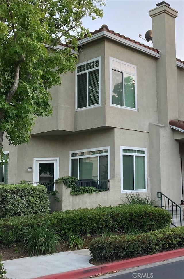 132 Sandpiper Ln, Aliso Viejo, CA 92656 - view of side of home with stucco siding and a chimney