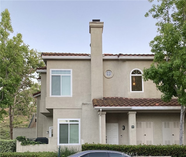 132 Sandpiper Ln, Aliso Viejo, CA 92656 - view of front of property featuring a tile roof, a chimney, and stucco siding