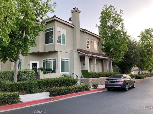 132 Sandpiper Ln, Aliso Viejo, CA 92656 - view of front of property featuring a chimney, stucco siding, and a tiled roof