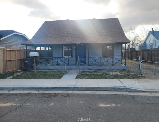 15943 L St, Mojave, CA 93501 - view of front facade with covered porch, a fenced front yard, and roof with shingles