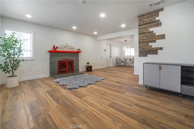 8283 Cornwall Ave, Rancho Cucamonga, CA 91739 - living area with wood finished floors, recessed lighting, healthy amount of natural light, a fireplace with raised hearth, and a chandelier