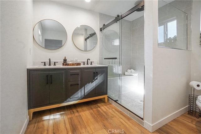 8283 Cornwall Ave, Rancho Cucamonga, CA 91739 - full bathroom featuring wood finished floors, a shower stall, and double vanity