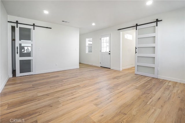 8283 Cornwall Ave, Rancho Cucamonga, CA 91739 - spare room with a barn door, light wood finished floors, and recessed lighting