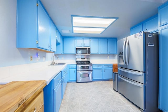 3833 Via Del Bardo, San Ysidro, CA 92173 - kitchen with stainless steel appliances, blue cabinetry, and light countertops
