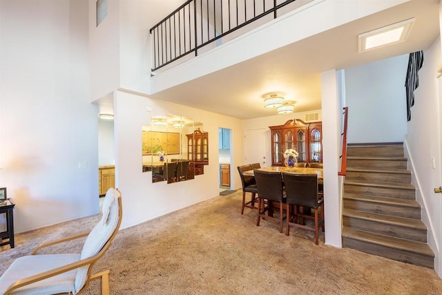 3833 Via Del Bardo, San Ysidro, CA 92173 - dining space featuring carpet flooring, stairway, and a towering ceiling