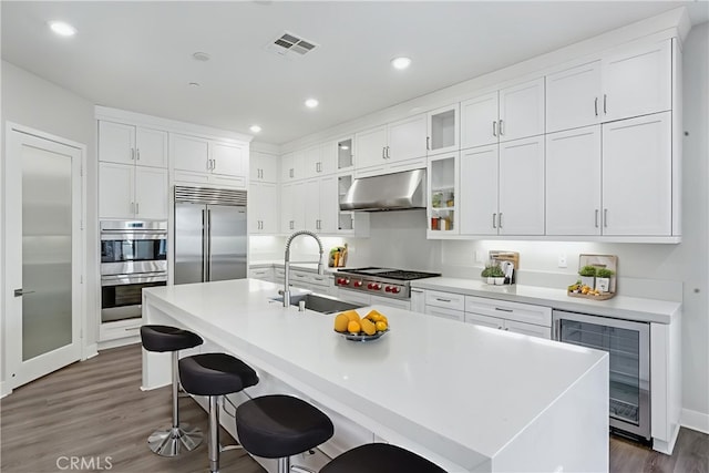 54 Sagan Way, Irvine, CA 92618 - kitchen featuring stainless steel appliances, under cabinet range hood, beverage cooler, dark wood finished floors, and white cabinets