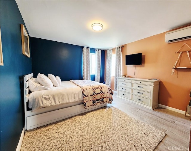 65076 E Broadway, Joshua Tree, CA 92252 - bedroom featuring a wall mounted air conditioner and light wood-style flooring