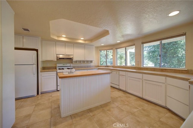 6305 Portola Rd, Atascadero, CA 93422 - kitchen with white appliances, wood counters, a textured ceiling, under cabinet range hood, and recessed lighting