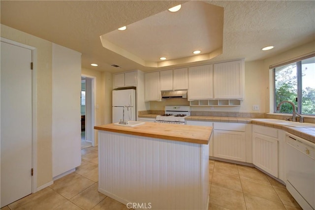 6305 Portola Rd, Atascadero, CA 93422 - kitchen featuring white appliances, recessed lighting, wooden counters, a tray ceiling, and light tile patterned flooring