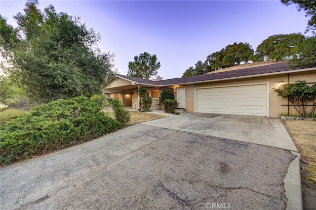 6305 Portola Rd, Atascadero, CA 93422 - ranch-style home with stucco siding, an attached garage, and asphalt driveway