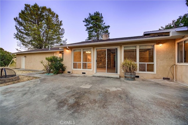 6305 Portola Rd, Atascadero, CA 93422 - back of house at dusk featuring a patio area, a fire pit, stucco siding, a chimney, and crawl space