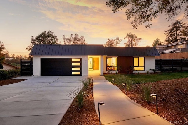 2025 Valley Rd, Oceanside, CA 92056 - contemporary house with a metal roof, an attached garage, stucco siding, and concrete driveway