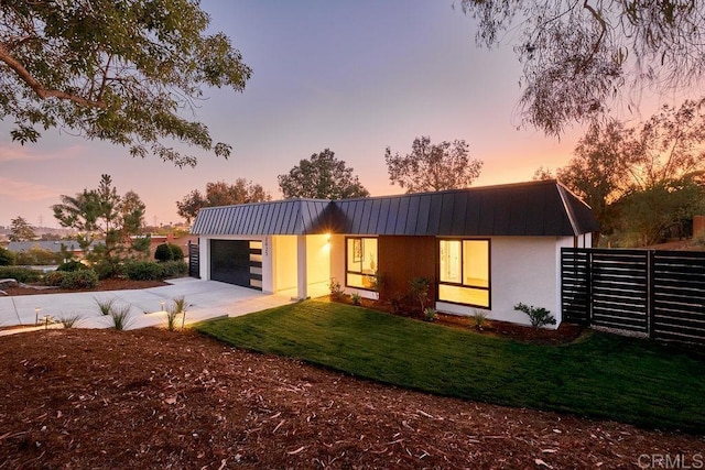 2025 Valley Rd, Oceanside, CA 92056 - contemporary home featuring driveway, a garage, a metal roof, stucco siding, and a lawn