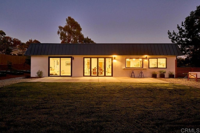 2025 Valley Rd, Oceanside, CA 92056 - back of house at dusk featuring a patio area, stucco siding, a metal roof, and a standing seam roof