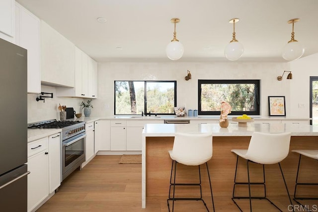 2025 Valley Rd, Oceanside, CA 92056 - kitchen with stainless steel appliances, light countertops, a breakfast bar, and light wood finished floors