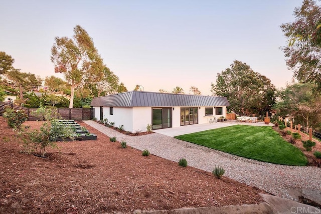 2025 Valley Rd, Oceanside, CA 92056 - back of property at dusk with a patio, stucco siding, and a metal roof