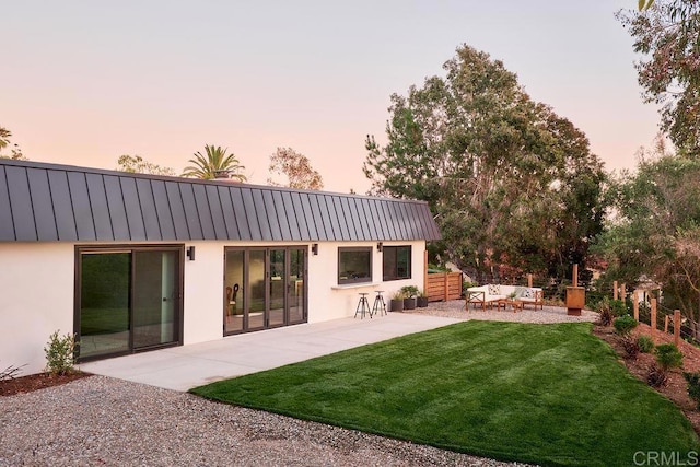 2025 Valley Rd, Oceanside, CA 92056 - rear view of house featuring stucco siding, a patio area, outdoor lounge area, a yard, and a metal roof