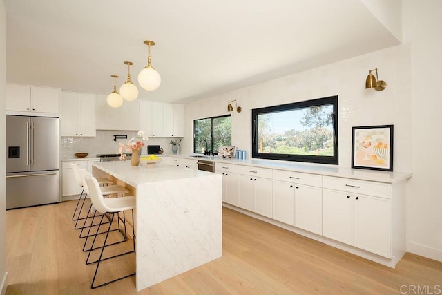 2025 Valley Rd, Oceanside, CA 92056 - kitchen featuring stainless steel appliances, decorative backsplash, a breakfast bar area, and white cabinetry
