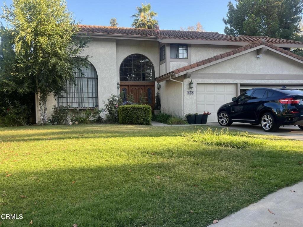 652 Stonebrook St, Simi Valley, CA 93065 - mediterranean / spanish-style house featuring a garage, a tiled roof, a front yard, and stucco siding