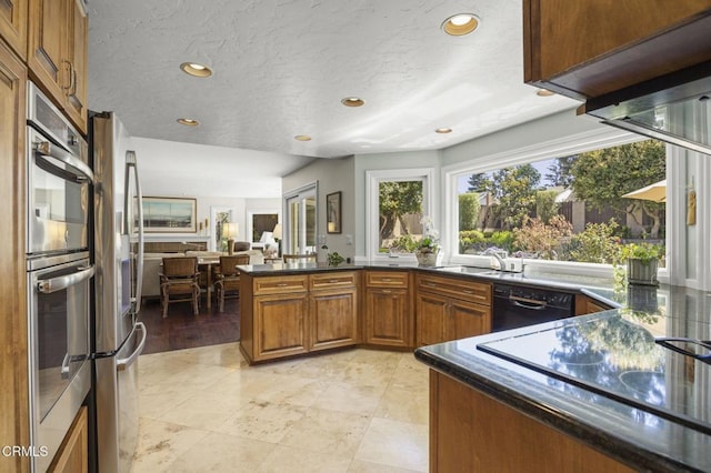 2142 Klamath Dr, Camarillo, CA 93010 - kitchen with black appliances, brown cabinets, open floor plan, recessed lighting, and a peninsula