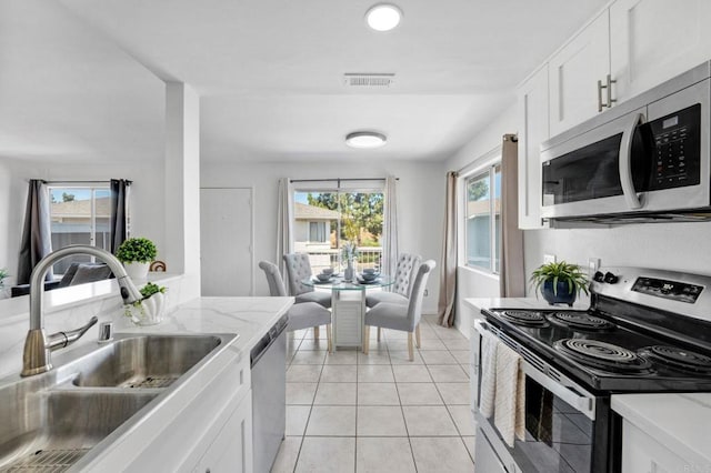 853 Dana Point Way, Oceanside, CA 92058 - kitchen with appliances with stainless steel finishes, white cabinets, light tile patterned flooring, and light stone counters